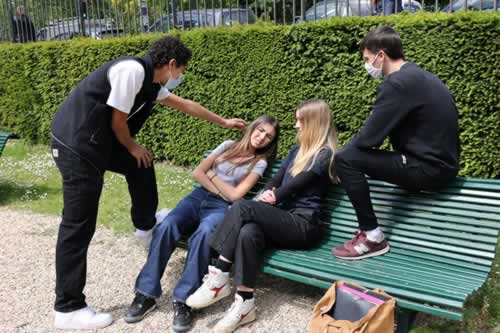 deux jeunes femmes harcelées par des jeunes hommes dans un square