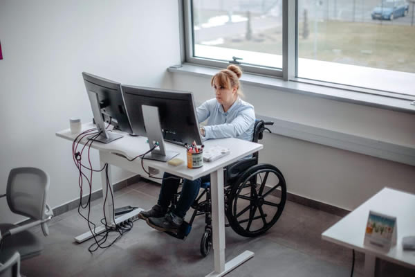 une personne en fauteuil roulant au travail dans un bureau