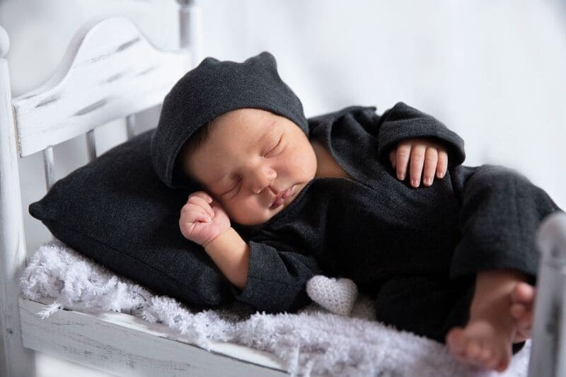 Un bébé dort paisiblement dans une couverture.